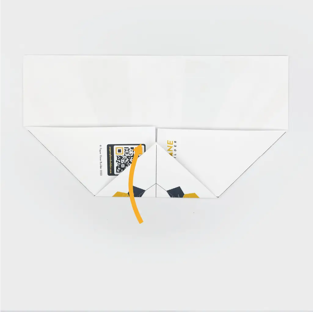 Then, fold the newly created point inward to create the nose of the plane.