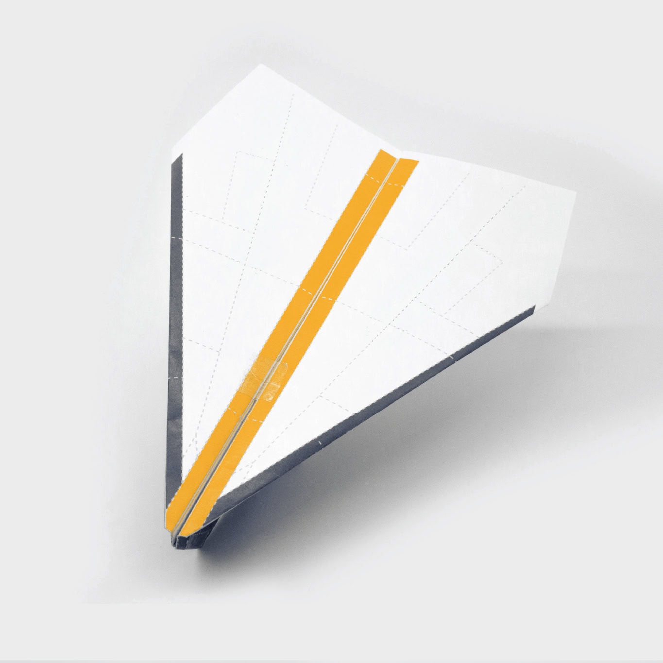 To maintain the paper planes shape add a small piece of tape to the top, nose, and bottom of the plane.