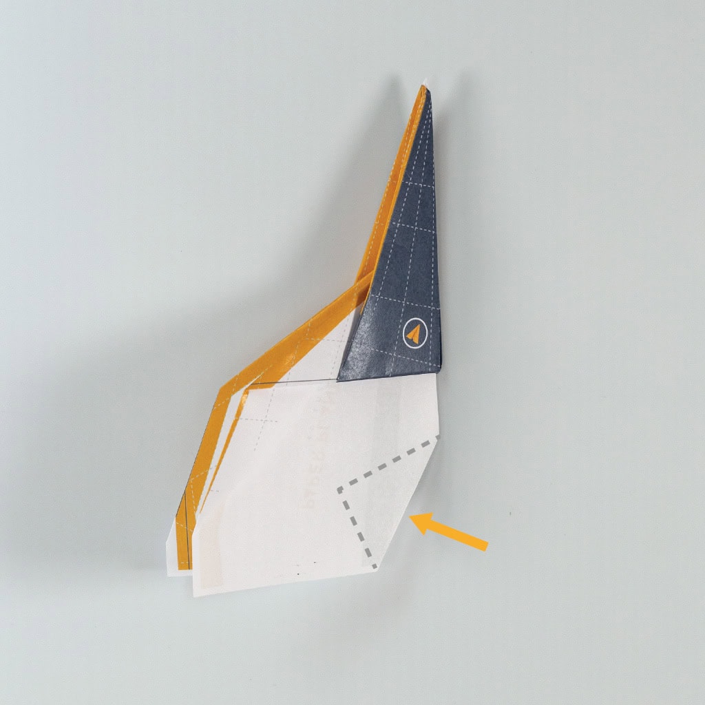 Reverse the fold so that the tail points inside the paper plane&rsquo;s fuselage.