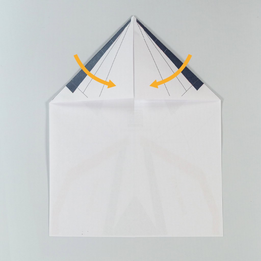 Fold the top left and right corners inward to create a guiding crease for the next step.