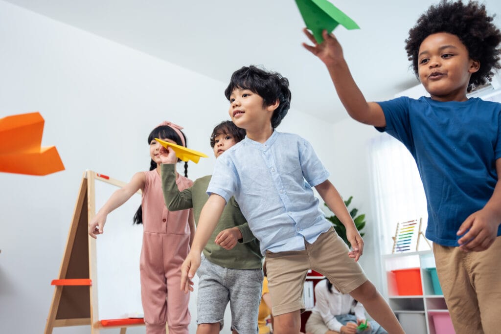 students throwing paper airplanes in a race to the finish line