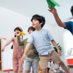students throwing paper airplanes in a race to the finish line