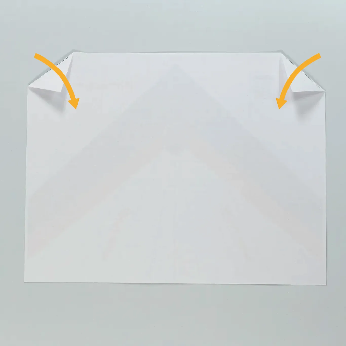 Fold the top tips of the upper left and right corners inward.