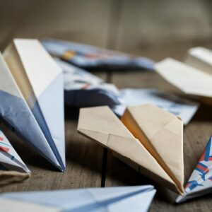 Colorful paper airplanes on wooden surface