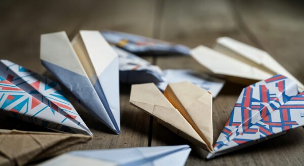 Colorful paper airplanes on wooden surface